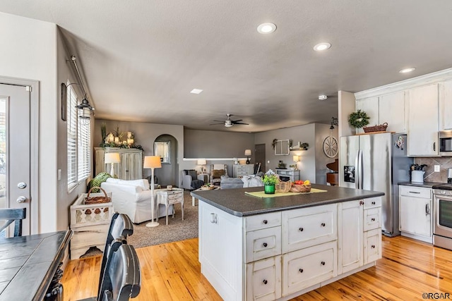 kitchen featuring white cabinetry, light hardwood / wood-style flooring, a center island, and appliances with stainless steel finishes