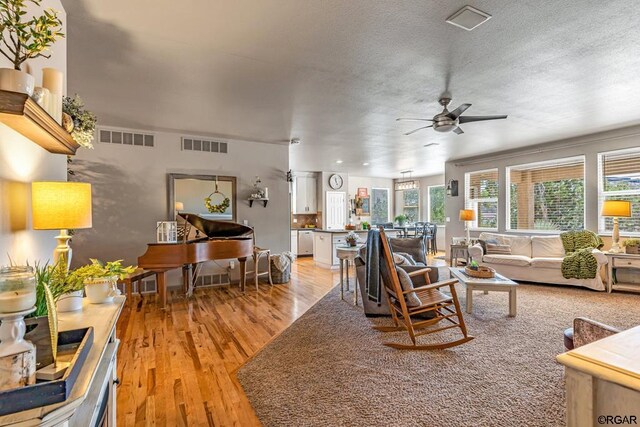 living room featuring ceiling fan and light hardwood / wood-style flooring