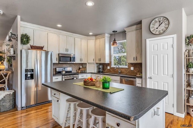 kitchen with sink, a center island, pendant lighting, stainless steel appliances, and decorative backsplash