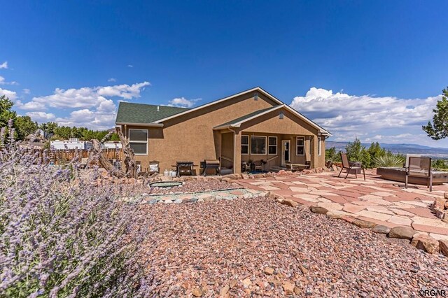 rear view of house featuring a jacuzzi and a patio area