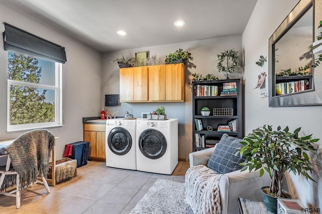 laundry room featuring light tile patterned flooring, cabinets, and washer and dryer