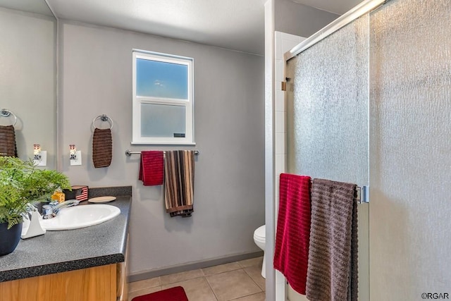 bathroom featuring an enclosed shower, vanity, tile patterned floors, and toilet