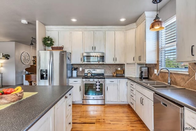 kitchen featuring hanging light fixtures, white cabinetry, appliances with stainless steel finishes, and sink