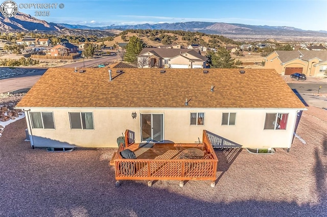 back of property with a deck with mountain view