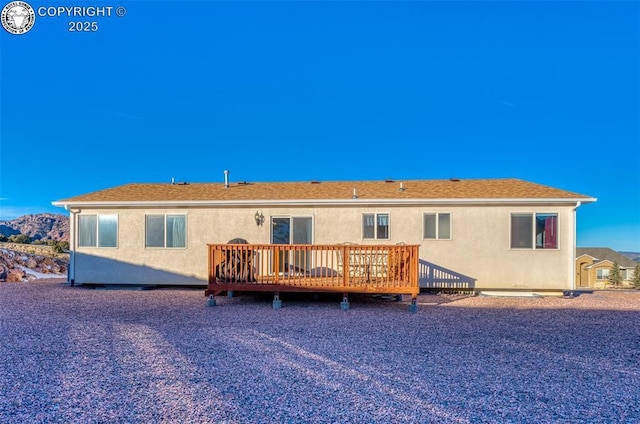 rear view of property featuring a wooden deck