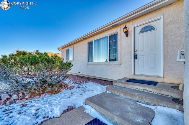 view of snow covered property entrance