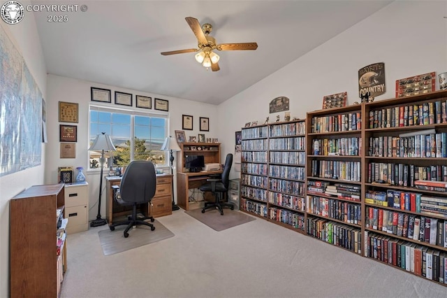 carpeted office space with ceiling fan and vaulted ceiling