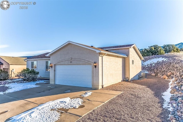 view of front of home featuring cooling unit and a garage