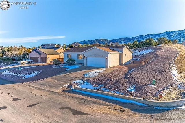 single story home with a mountain view and a garage