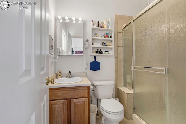 bathroom with vanity, toilet, and a shower with shower door