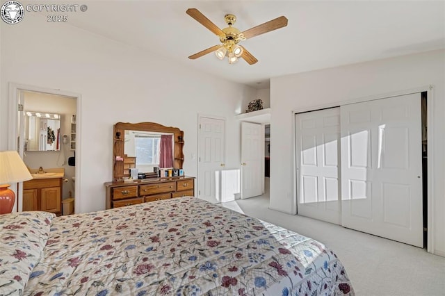 carpeted bedroom with lofted ceiling, sink, ceiling fan, connected bathroom, and a closet