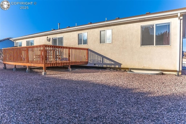 rear view of property featuring a wooden deck