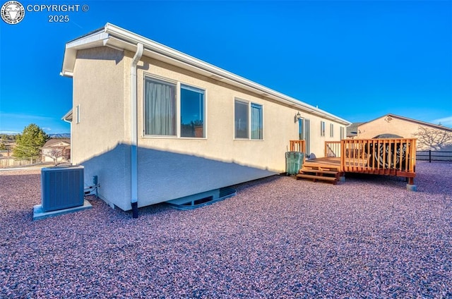 rear view of house with a wooden deck and central AC