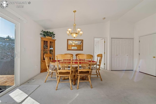 carpeted dining space with an inviting chandelier and vaulted ceiling