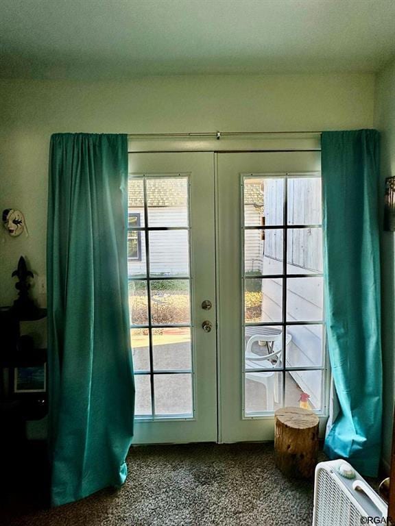 entryway featuring french doors, a healthy amount of sunlight, and carpet