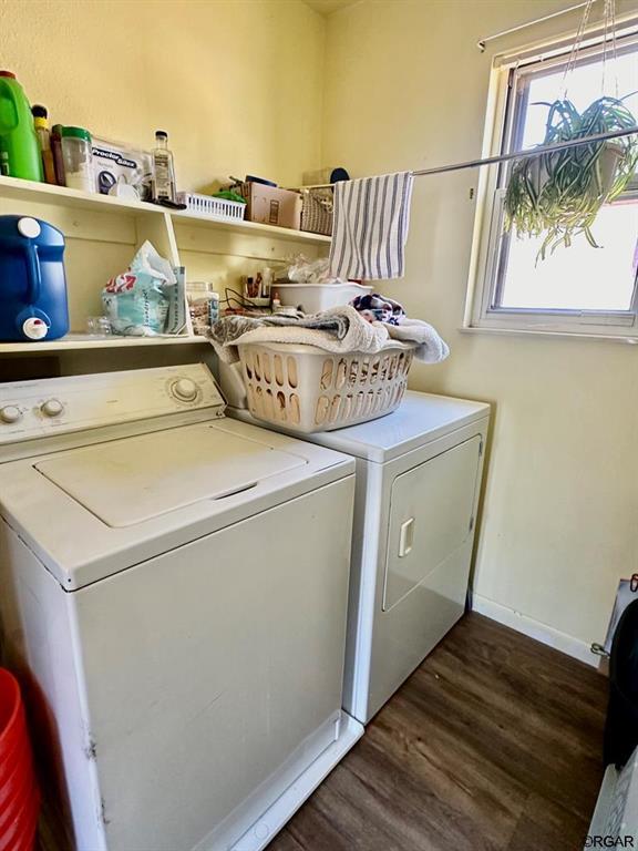 washroom with washing machine and dryer and dark hardwood / wood-style flooring