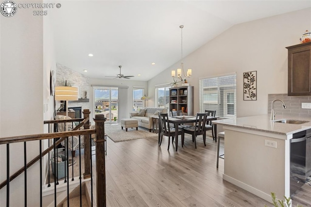 16840 New Autumn Dr, Monument, CO 80132 - kitchen with a sink, vaulted ceiling, backsplash, light wood-style flooring, and dishwashing machine