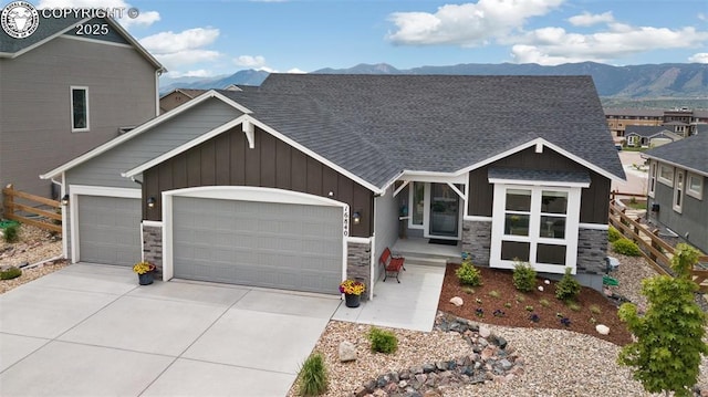 16840 New Autumn Dr, Monument, CO 80132 - craftsman-style home with board and batten siding, stone siding, a garage, a mountain view, and concrete driveway