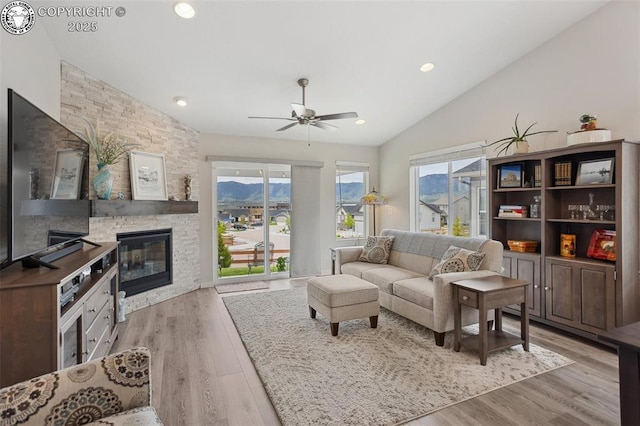 16840 New Autumn Dr, Monument, CO 80132 - living area with lofted ceiling, wood finished floors, ceiling fan, a fireplace, and recessed lighting