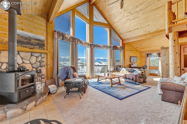 tiled living area with beamed ceiling, a wood stove, high vaulted ceiling, and wood ceiling