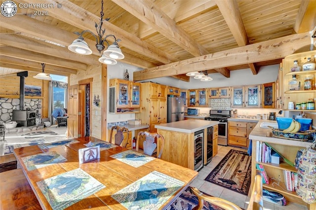 dining area featuring a wood stove, beverage cooler, wood ceiling, and beam ceiling
