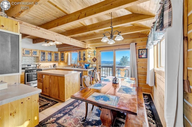 kitchen featuring wood walls, stainless steel gas stove, wooden ceiling, an inviting chandelier, and light countertops