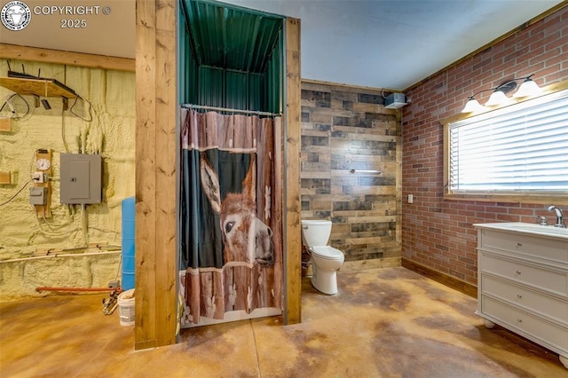 bathroom with electric panel, toilet, unfinished concrete floors, vanity, and brick wall