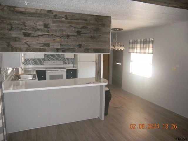 kitchen with sink, white appliances, white cabinetry, decorative light fixtures, and kitchen peninsula