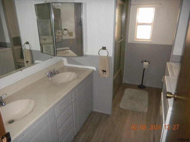 full bathroom with bathtub / shower combination, vanity, toilet, and hardwood / wood-style floors