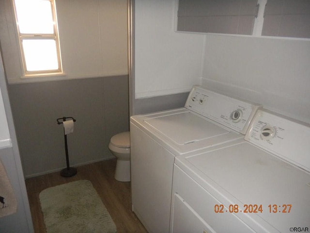 washroom with hardwood / wood-style flooring and washing machine and clothes dryer