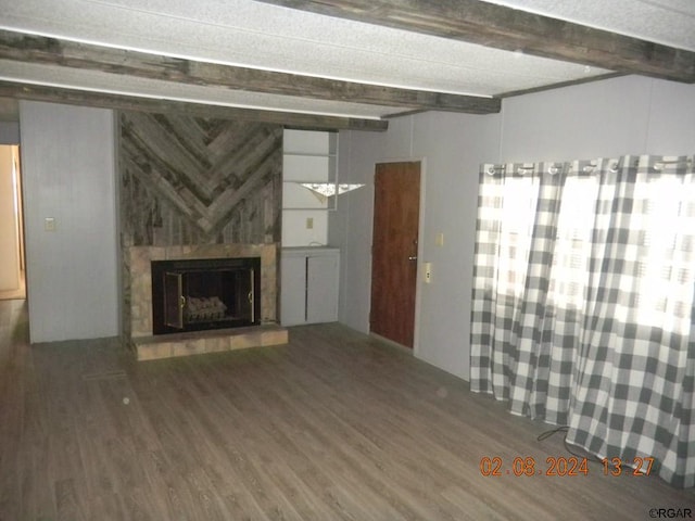 unfurnished living room with beam ceiling, dark hardwood / wood-style floors, and wood walls