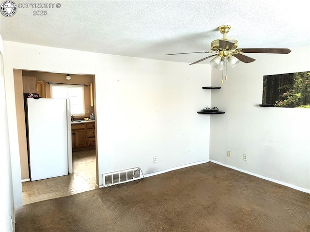 spare room featuring ceiling fan and a textured ceiling