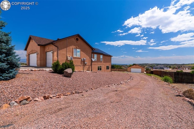 46 Wild Rose Dr, Canon City, CO 81212 - view of side of property featuring concrete driveway, stucco siding, an attached garage, and an outdoor structure