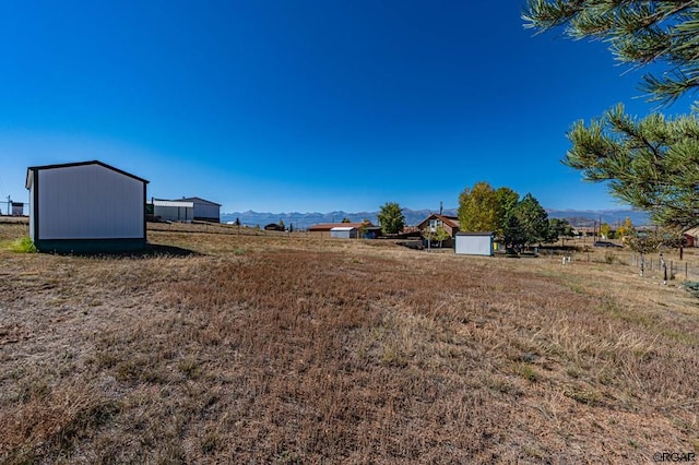 view of yard with a mountain view and a rural view