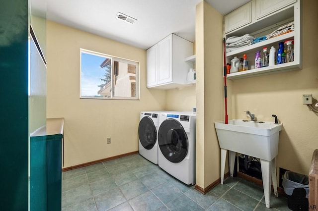 laundry area featuring washer and clothes dryer and cabinets