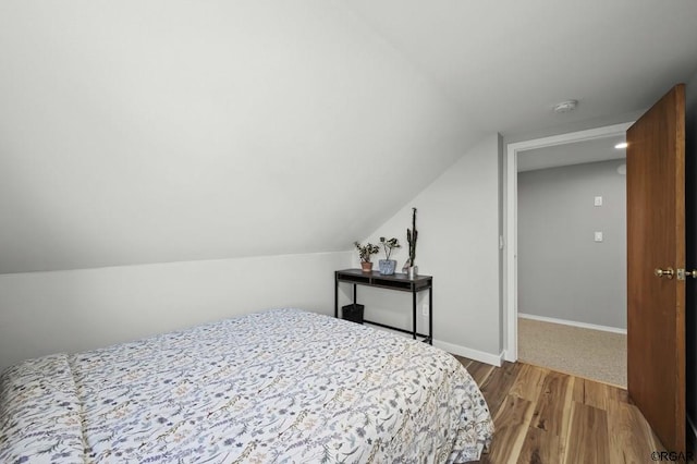 bedroom featuring lofted ceiling and wood-type flooring