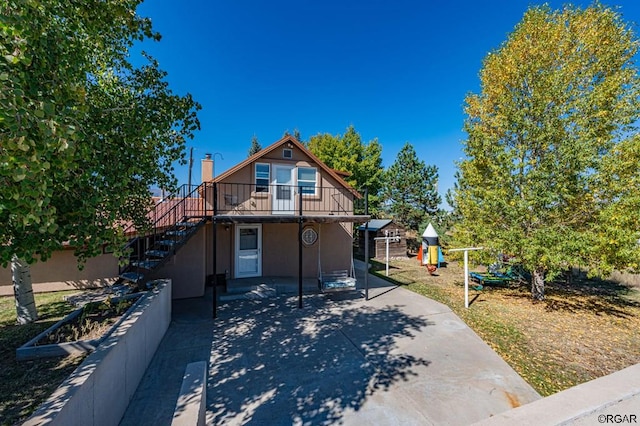 view of front of house with a playground and a patio area