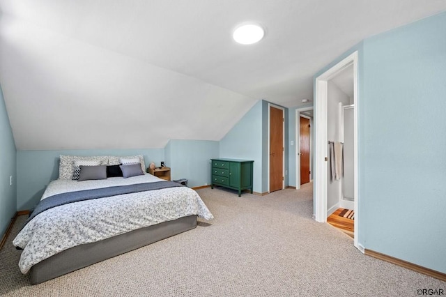 carpeted bedroom with lofted ceiling and ensuite bathroom