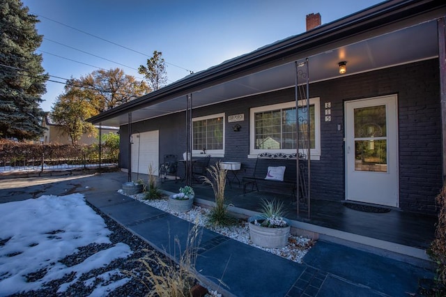 exterior space with a porch and a garage