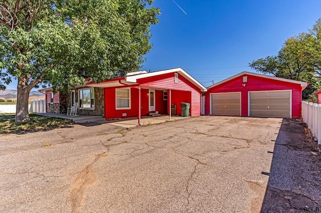 ranch-style home featuring a garage and an outbuilding