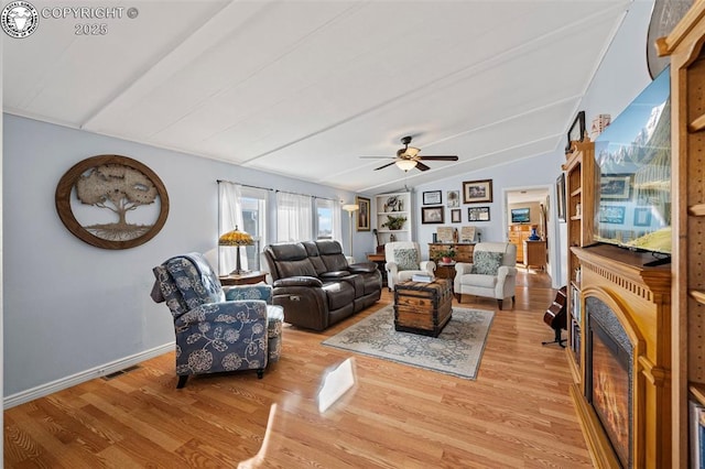 living room featuring ceiling fan, lofted ceiling, and light hardwood / wood-style flooring