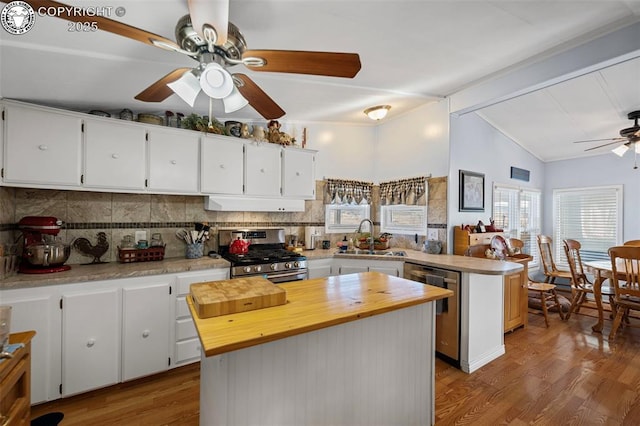 kitchen with decorative backsplash, appliances with stainless steel finishes, a kitchen island, and white cabinets