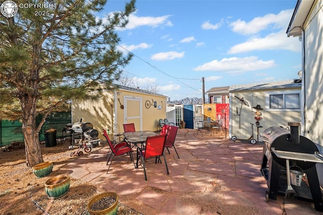 view of patio / terrace with area for grilling and a shed