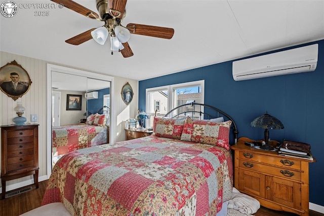 bedroom with a wall mounted air conditioner, hardwood / wood-style floors, a closet, and ceiling fan