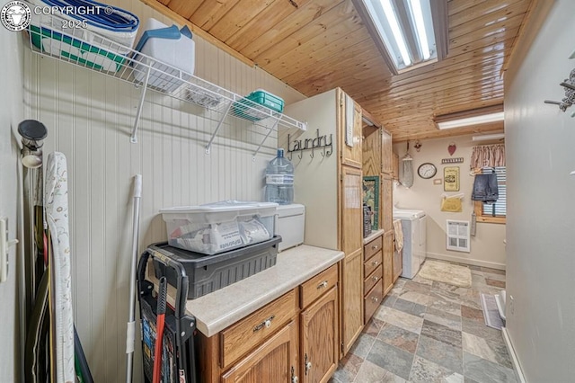 136 Beneaton Ln, Westcliffe, CO 81252 - laundry room featuring washing machine and clothes dryer, light stone finish flooring, baseboards, and wood ceiling