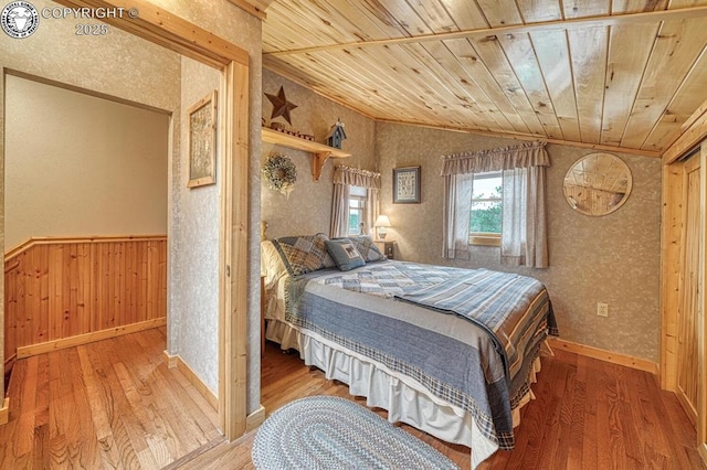 136 Beneaton Ln, Westcliffe, CO 81252 - bedroom with wood ceiling, wallpapered walls, wood-type flooring, baseboards, and vaulted ceiling