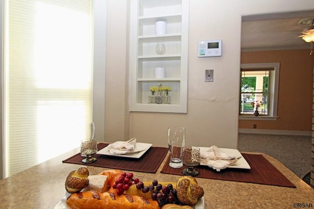 dining area featuring built in features, ceiling fan, and carpet flooring