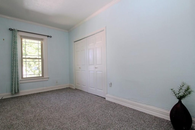 unfurnished bedroom with crown molding, carpet flooring, and a closet