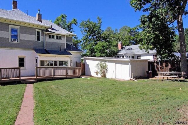 rear view of house with a deck and a lawn