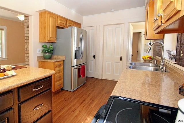 kitchen with sink, light hardwood / wood-style flooring, and stainless steel fridge with ice dispenser